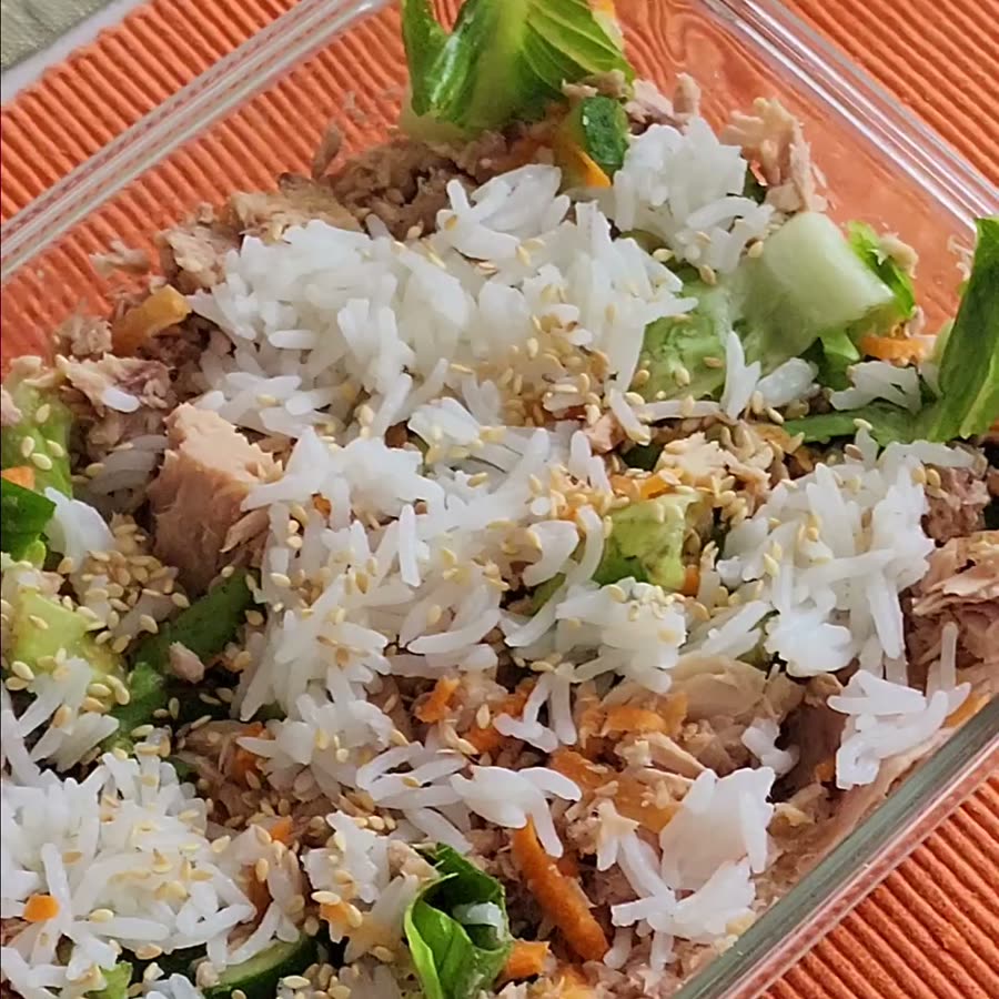 Tuna poke bowl with rice, cucumber, carrot, lettuce and sesame seeds